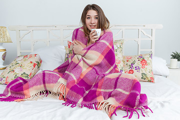 Image showing Sick woman covered with blanket holding cup of tea