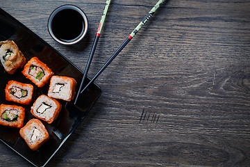 Image showing Sushi roll with chopsticks