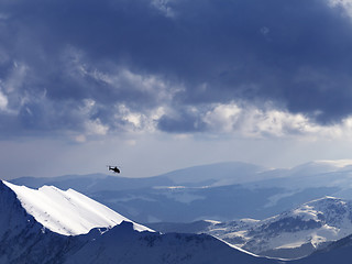 Image showing Off-piste slope for heliskiing and helicopter in evening