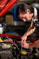 Image showing Auto mechanic fixing car engine