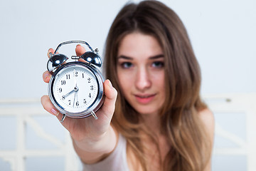 Image showing The young girl in bed with  clock service