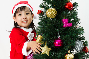 Image showing Asian Chinese little girl posing with Christmas Tree