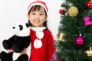 Image showing Asian Chinese little girl holding panda doll posing with Christm