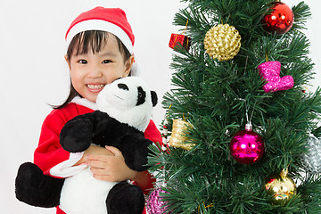 Image showing Asian Chinese little girl holding panda doll posing with Christm