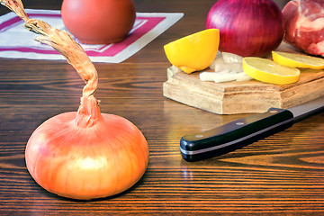 Image showing The still life: large onion and lemon on the table.