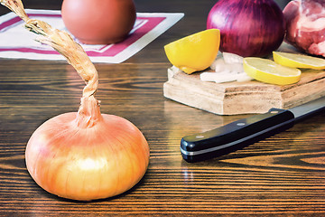 Image showing The still life: large onion and lemon on the table.