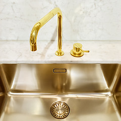 Image showing Kitchen sink with golden faucet