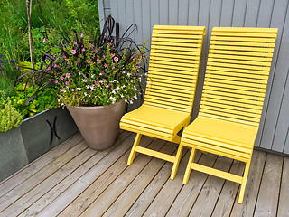 Image showing Yellow chairs and flowers decorating house exterior