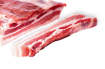 Image showing Cut a piece of bacon next to a large