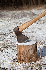 Image showing Axe and log in winter forest