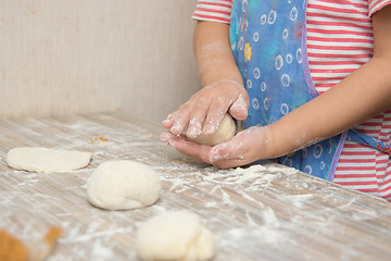 Image showing Girl sculpts a pie, close-up