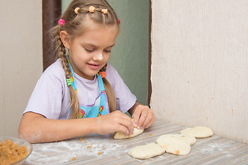 Image showing Cheerful six year old girl sculpts cakes with cabbage