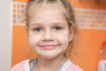 Image showing Portrait of a cheerful girl with a face stained with flour