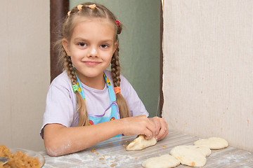 Image showing Cheerful girl sculpts cakes with cabbage