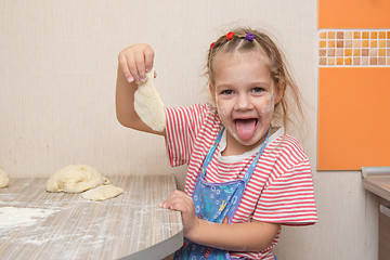 Image showing Happy little girl blinded blank for cakes at the kitchen table