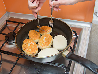 Image showing The hostess turns two forks cake in the pan