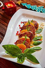 Image showing Grilled pork with mandarin oranges decorated and basil 