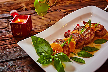 Image showing Grilled pork with mandarin oranges decorated and basil 