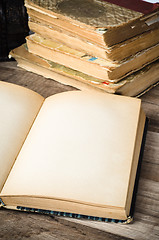 Image showing Open old book on a wooden surface 