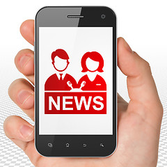 Image showing News concept: Hand Holding Smartphone with Anchorman on display