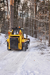 Image showing The tractor clears snow from the road