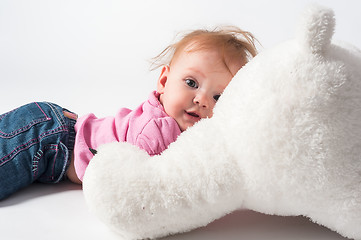 Image showing Baby girl plays with white bear toy