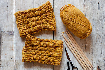 Image showing wool yellow legwarmers, scissors, knitting needles and yarn 