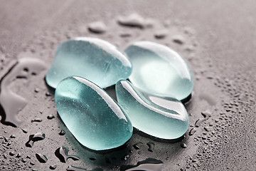 Image showing wet glass pieces polished by the sea