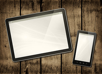Image showing Smartphone and digital tablet PC on a dark wood table