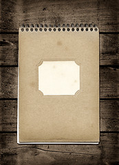 Image showing Closed spiral Note book on a dark wood table