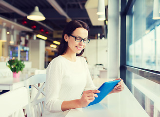 Image showing smiling woman with tablet pc at cafe