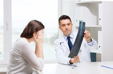 Image showing smiling male doctor in white coat looking at x-ray