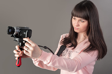 Image showing Young pretty woman with video camera