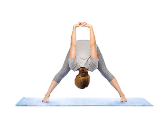 Image showing woman making yoga wide-legged forward bend on mat