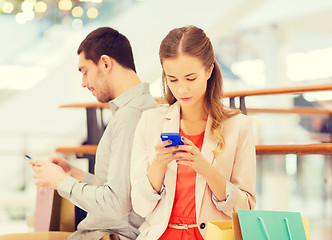 Image showing couple with smartphones and shopping bags in mall