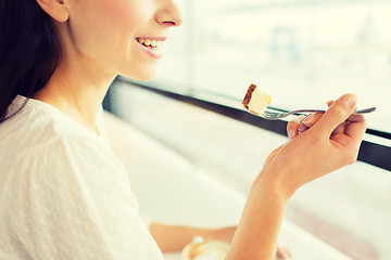 Image showing close up of woman eating cake at cafe or home