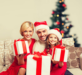 Image showing smiling family giving many gift boxes