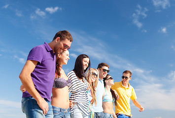 Image showing group of happy friends walking along beach