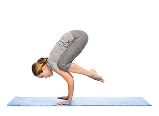 Image showing woman making yoga in crane pose on mat