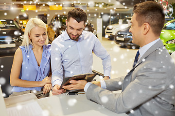 Image showing happy couple with car dealer in auto show or salon