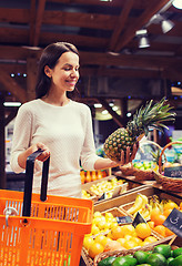 Image showing happy young woman with food basket in market