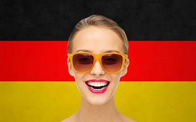 Image showing happy young woman in sunglasses over german flag