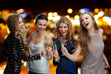 Image showing happy women clinking champagne glasses over lights