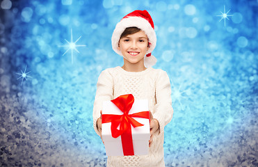 Image showing smiling happy boy in santa hat with gift box