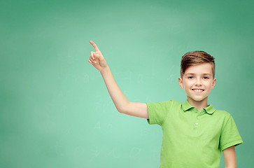 Image showing happy boy in green polo t-shirt pointing finger up