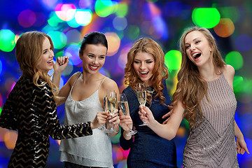 Image showing happy women clinking champagne glasses over lights