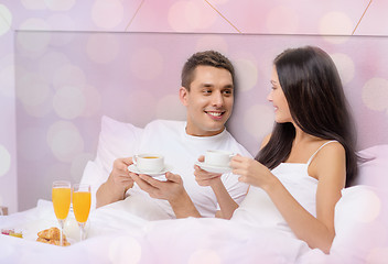Image showing happy couple having breakfast in bed at hotel