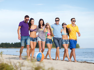 Image showing group of happy friends walking along beach