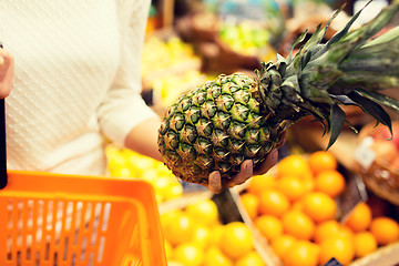 Image showing close up of woman with pineapple in grocery market