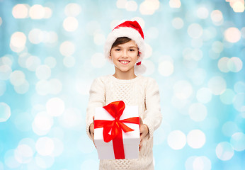 Image showing smiling happy boy in santa hat with gift box